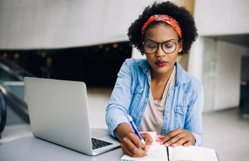 a female designer taking notes in a notebook