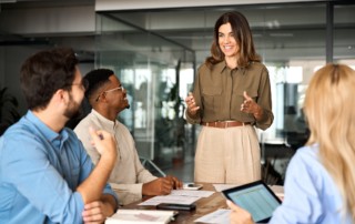 Multilingual female manager giving presentation to colleagues