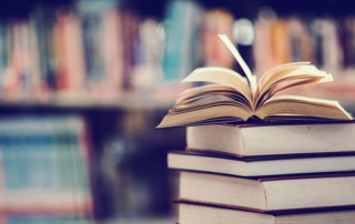 diversi libri uno sopra all'altro in una libreria o biblioteca