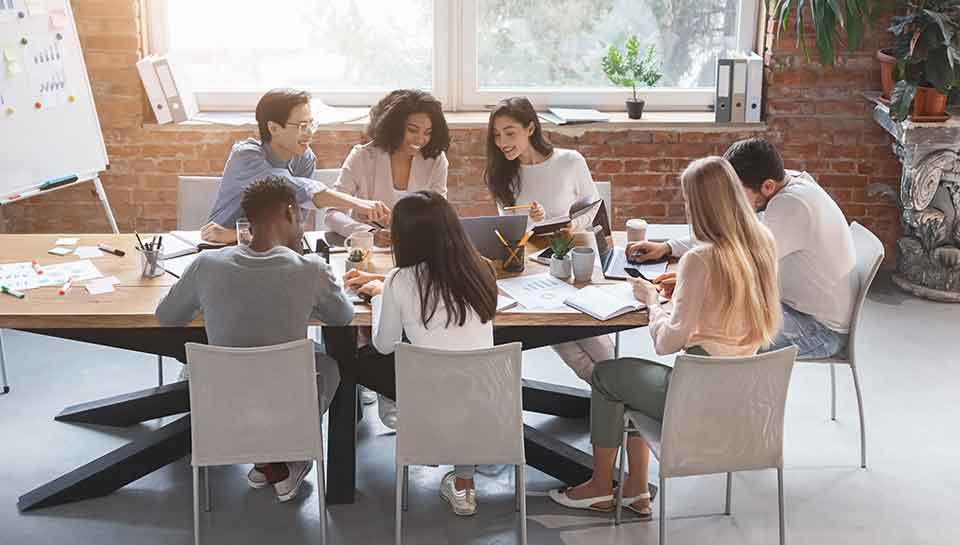 gruppo di lavoro eterogeneo attorno a un tavolo