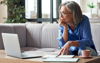 Donna seduta sul divano davanti al pc che effettua del digital coaching