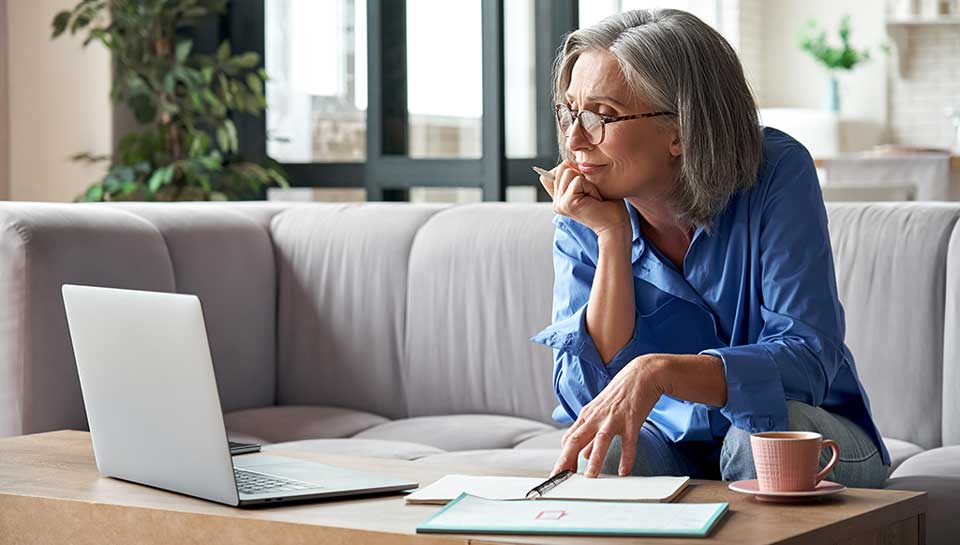 Donna seduta sul divano davanti al pc che effettua del digital coaching