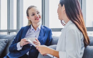 donne d'affari sedute su un divano che parlano di lavoro
