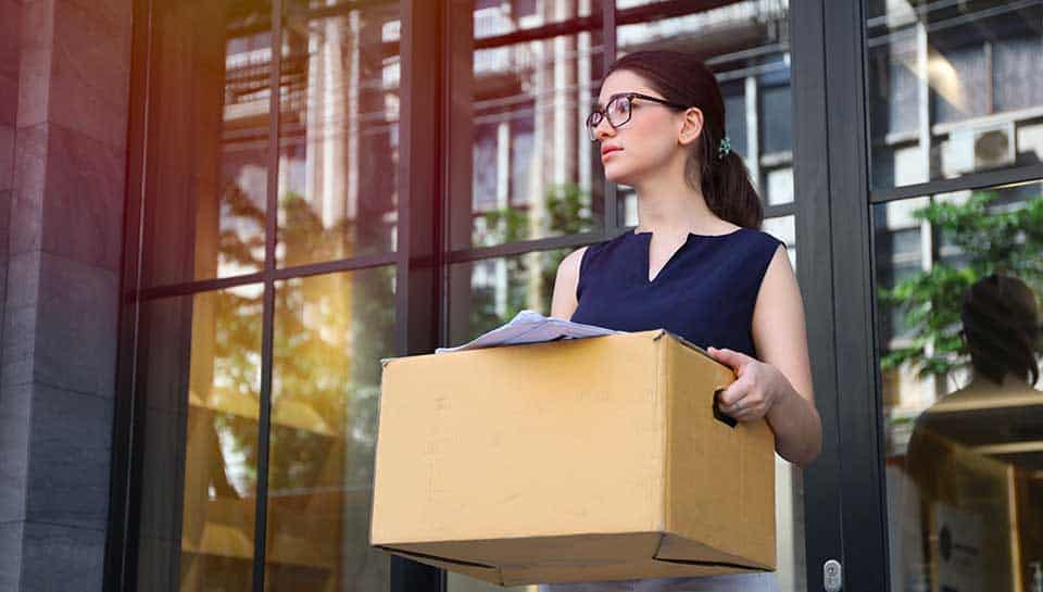 ragazze che abbandona il luogo lavorativo con una scatola delle sue cose