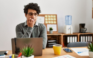 ragazzo che appare insicuro e pensieroso davanti allo schermo del pc