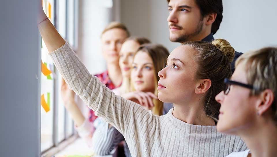 gruppo di ragazzi e ragazze che lavorano davanti una lavagna