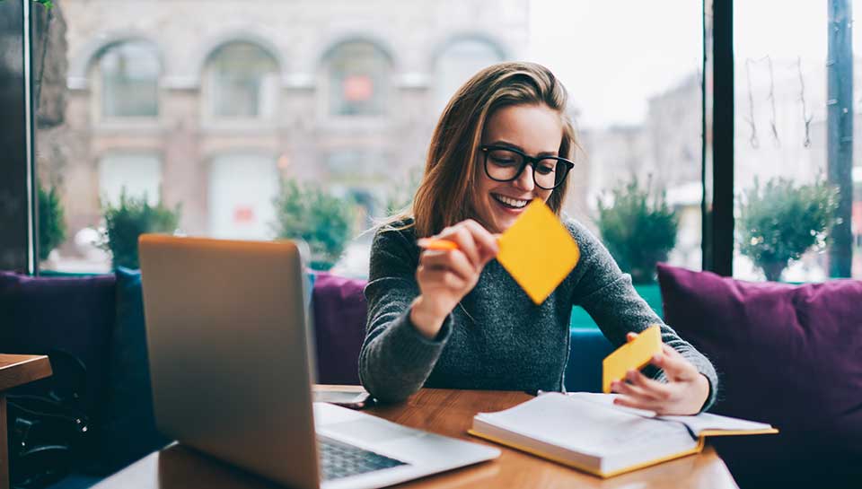 ragazza alla scrivania in ufficio che sta creando una mappa mentale con dei post-it