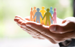 mano che regge degli omini fatti di carta che formano un cerchio