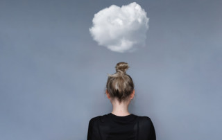 ragazza di spalle con sopra una nuvoletta che rappresenta la stanchezza mentale