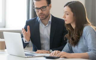 un uomo e una donna due colleghi che stanno davanti al pc