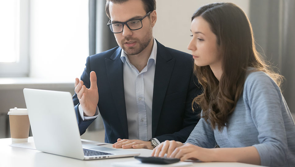 un uomo e una donna due colleghi che stanno davanti al pc