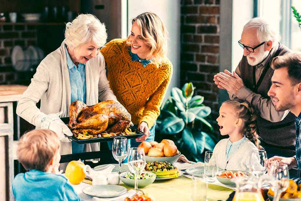 famiglia che si ritrova a tavola per il pranzo alla festa del ringraziamento