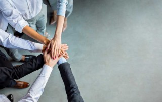 team che celebra l'unione mettendo le mani una sopra l'altra