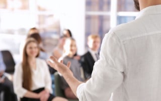 ragazzo che fa presentazione davanti una platea