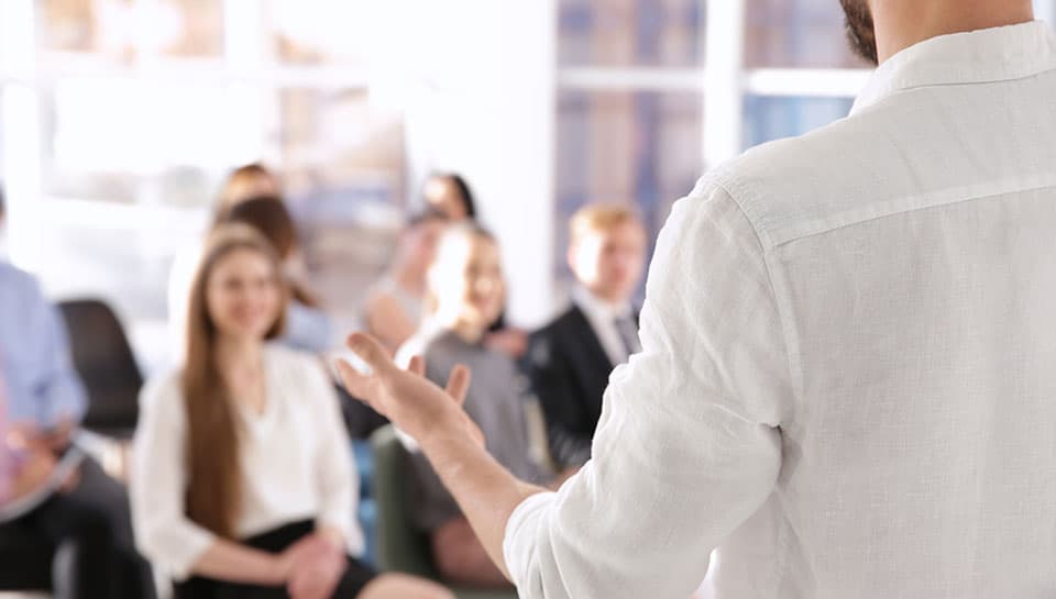 ragazzo che fa presentazione davanti una platea